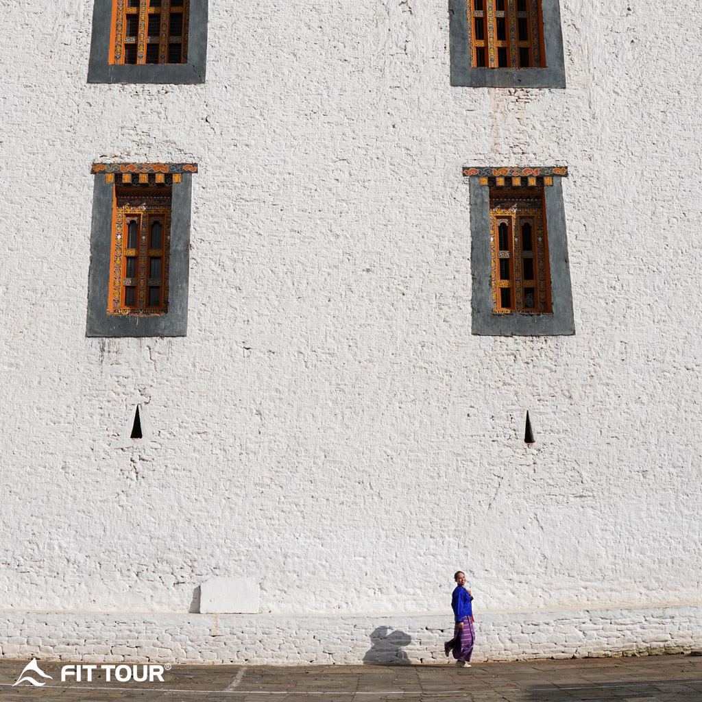 Du khách chụp trước kiến trúc tu viện với tường trắng
