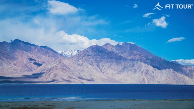 Hồ Pangong với vẻ đẹp hoang sơ, bình yên, mặt nước trong veo phản chiếu bầu trời xanh và dãy núi hùng vĩ