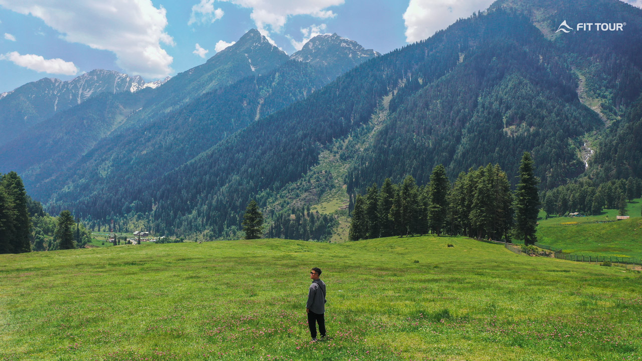 Du khách chụp ảnh cùng bãi cỏ xanh ở thung lũng Aru Kashmir