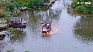 Khung cảnh thuyền truyền thống lướt trên mặt nước tĩnh lặng của Cát Tiên Thôn, tạo nên một trải nghiệm thư giãn và thơ mộng