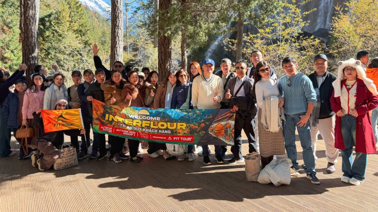 Đoàn khách Tour Dealer Trung Quốc chụp ảnh lưu niệm trước khung cảnh núi non hùng vĩ tại Cửu Trại Câu