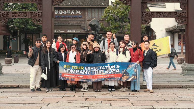 Nhóm khách du lịch chụp ảnh kỷ niệm tại cổng vào khu dịch vụ tại Thị trấn nước Ô Trấn
