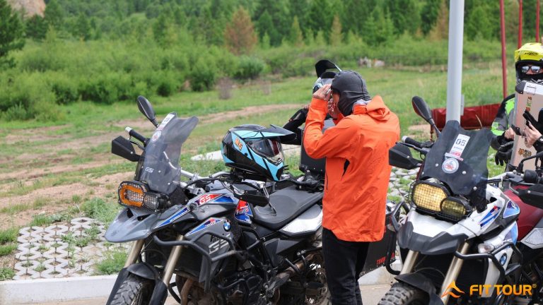 Một thành viên đoàn phượt chuẩn bị trang bị bảo hộ và mũ bảo hiểm trước khi khởi hành – hình ảnh quen thuộc trong các hành trình mô tô xuyên Công viên quốc gia Terelj tại Mông Cổ