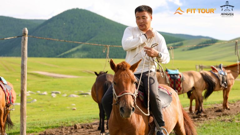 Một hướng dẫn viên địa phương Mông Cổ hỗ trợ du khách cưỡi ngựa trong thung lũng Orkhon – nơi kết nối du lịch trải nghiệm và văn hóa bản địa chân thực