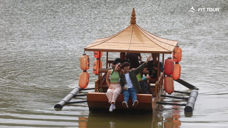 Du khách trải nghiệm đi thuyền gỗ mái che treo đèn lồng đỏ trên hồ Ban Rak Thai, Mae Hong Son, Thái Lan