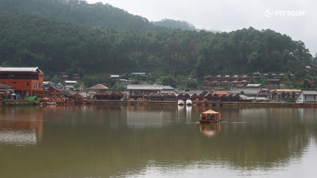 Toàn cảnh hồ trung tâm làng Ban Rak Thai với nhà gỗ và đồi thông bao quanh ở Mae Hong Son, Thái Lan