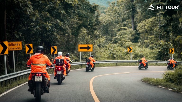 Đoàn motor FIT TOUR mặc áo phản quang màu cam nổi bật, di chuyển an toàn qua những khúc cua uốn lượn giữa rừng tại cung đường Mae Hong Son, Chiang Mai, Thái Lan