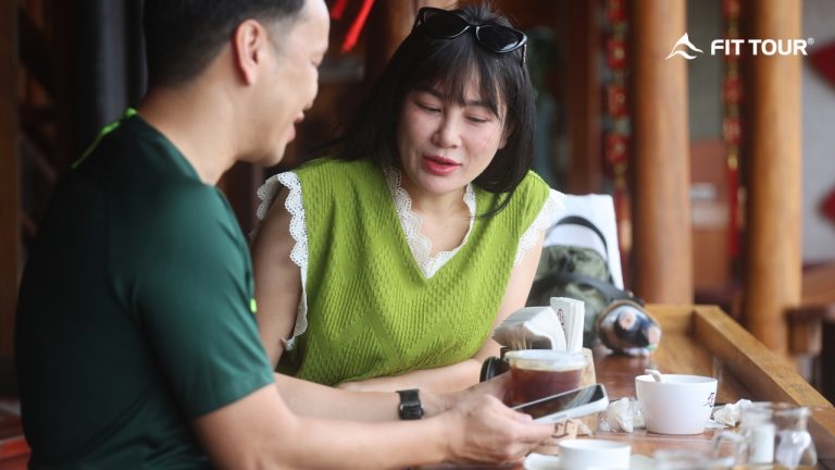 Cặp đôi du lịch Thái Lan cùng FIT Tour ngồi thưởng thức cà phê và trò chuyện trong không gian quán ấm cúng