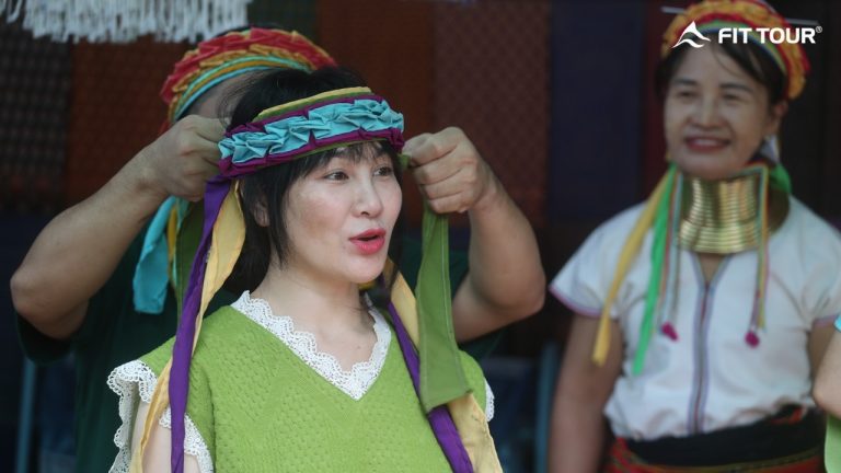 Du khách trải nghiệm đội khăn truyền thống của người Karen cổ dài tại làng Long Neck Karen, Mae Hong Son, Thái Lan