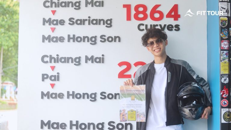 Du khách cầm chứng nhận “1864 Curves” tại checkpoint Mae Hong Son Loop – biểu tượng cung đường huyền thoại Thái Lan