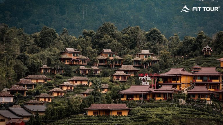 Dãy nhà cổ truyền mái ngói đỏ trải đều trên đồi chè tại làng Ban Rak Thai, nổi bật giữa thiên nhiên hùng vĩ của Mae Hong Son, Thái Lan