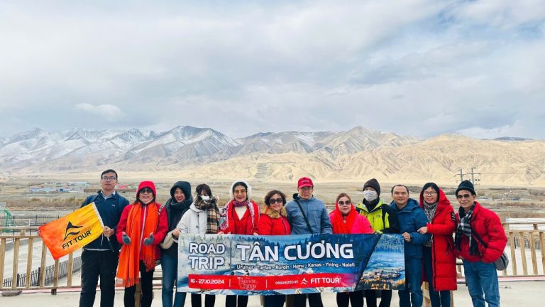Đoàn khách FIT Tour check-in tại Hồ Bạch Sa, Nam Cương với phông nền núi tuyết và sa mạc hùng vĩ trong hành trình road trip Tân Cương
