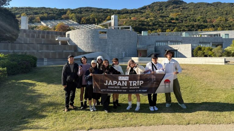 Thành viên đoàn check-in tại Garden of Fine Arts Kyoto, phía sau là bản in tác phẩm Renoir trong không gian bê tông của Tadao Ando.