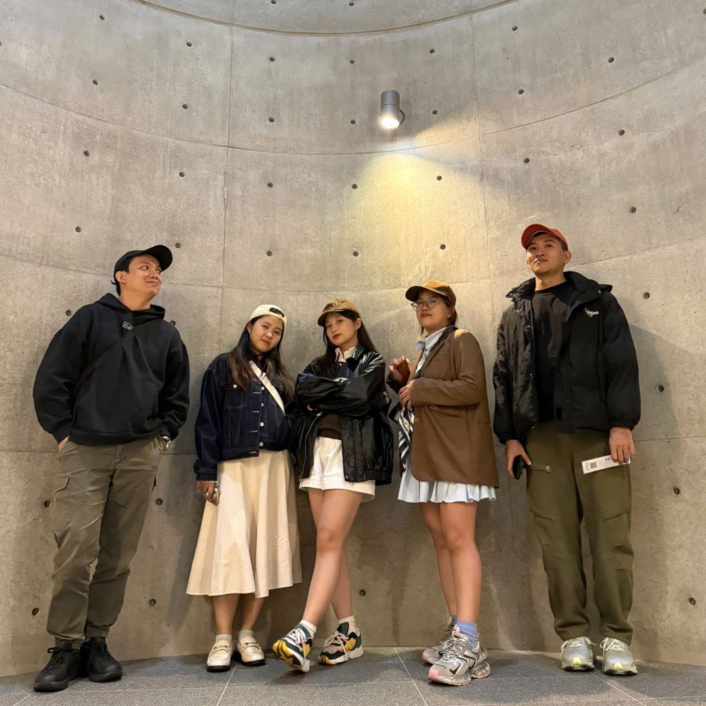 Thành viên đoàn MM Trip Japan chụp ảnh trong không gian tường bê tông tối giản tại Tadao Ando Architect & Associates, đặc trưng phong cách kiến trúc Ando