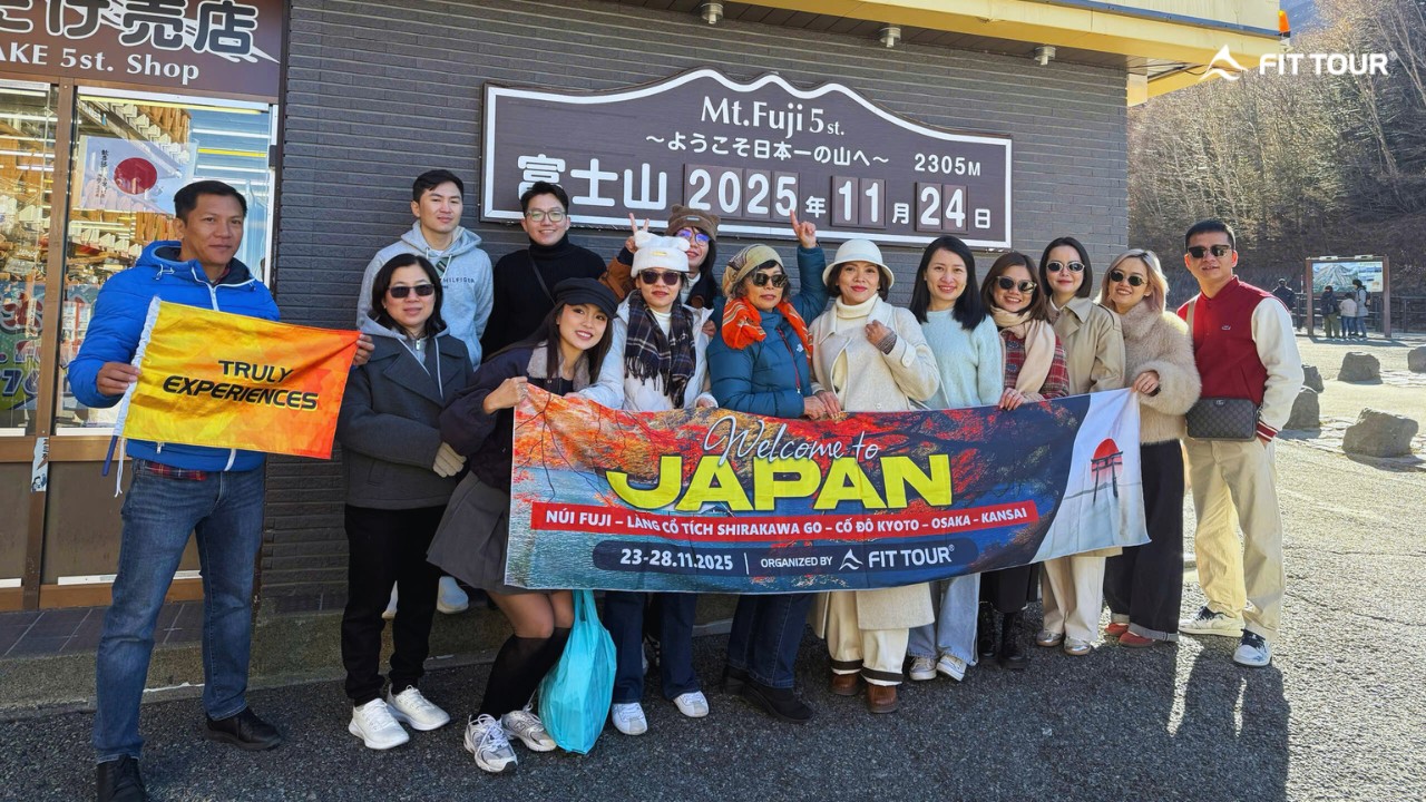 Khách hàng check-in tại bảng mốc độ cao 2305m của Trạm số 5 Núi Phú Sĩ, ghi dấu kỷ niệm tháng 11/2025.