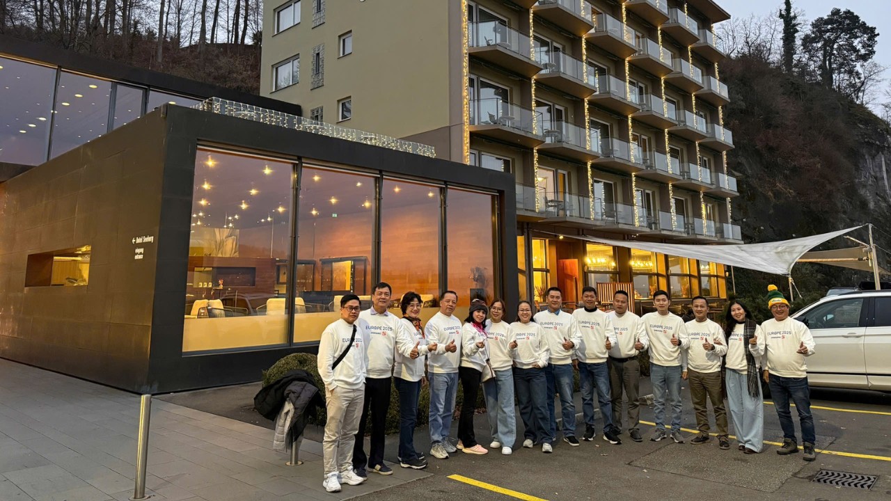 Các thành viên đoàn Samsung Vietnam trong trang phục đồng điệu chụp ảnh trước khách sạn nghỉ dưỡng sang trọng tại Châu Âu vào buổi tối, thể hiện tiêu chuẩn dịch vụ cao cấp của chuyến Incentive