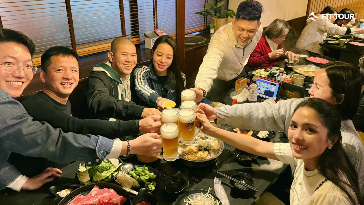 Không khí ấm cúng của bữa tối với lẩu Nhật Bản và bia tươi sau một ngày tham quan.